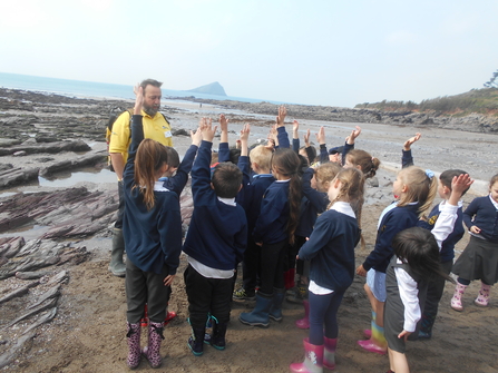 Wembury assistant delivering talk on beach to pupils from woodfield primary school in Plymouth